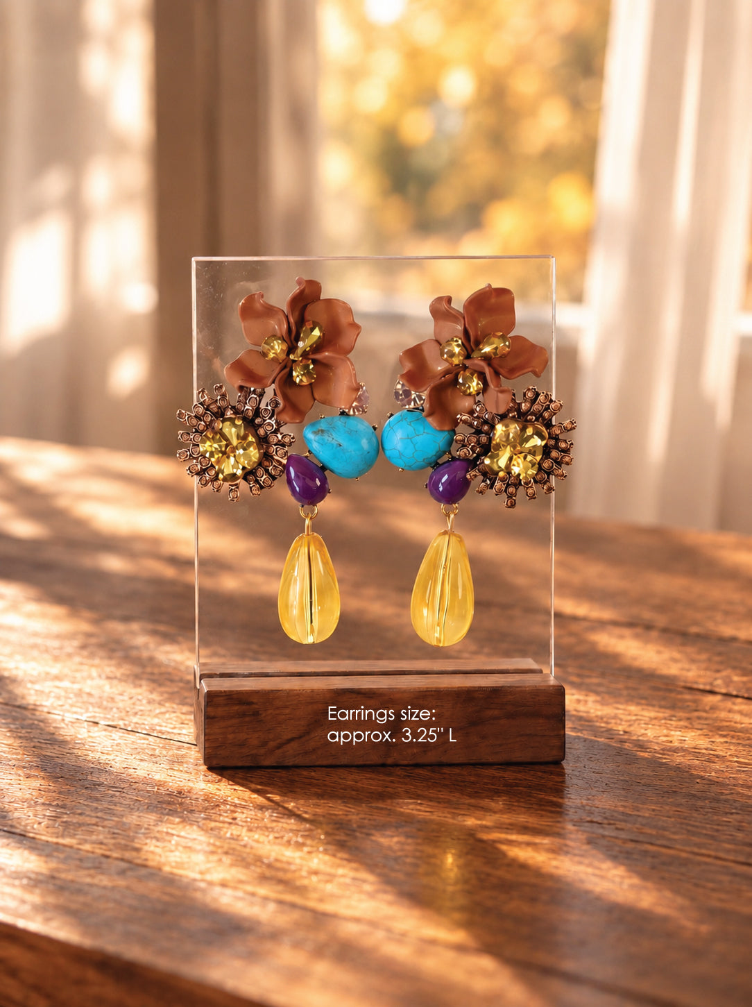 a pair of statement floral earrings, displayed on a base