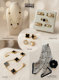Layered gold-tone necklace with black and white clover accents displayed on a neutral bust, part of the Black Clover Muse Gift Set by Thinking Presents™