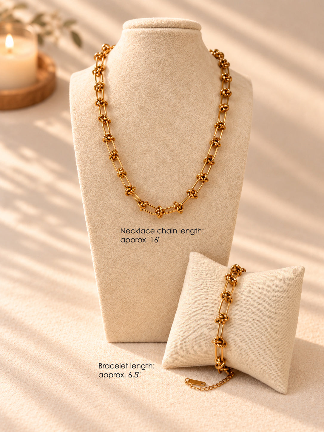 Gold knot chain necklace, approx. 16 inches, and matching gold knot chain bracelet, approx. 6.5 inches, on a display stand