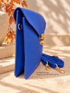 Side view of cobalt blue vegan crossbody bag with gold hardware and removable strap