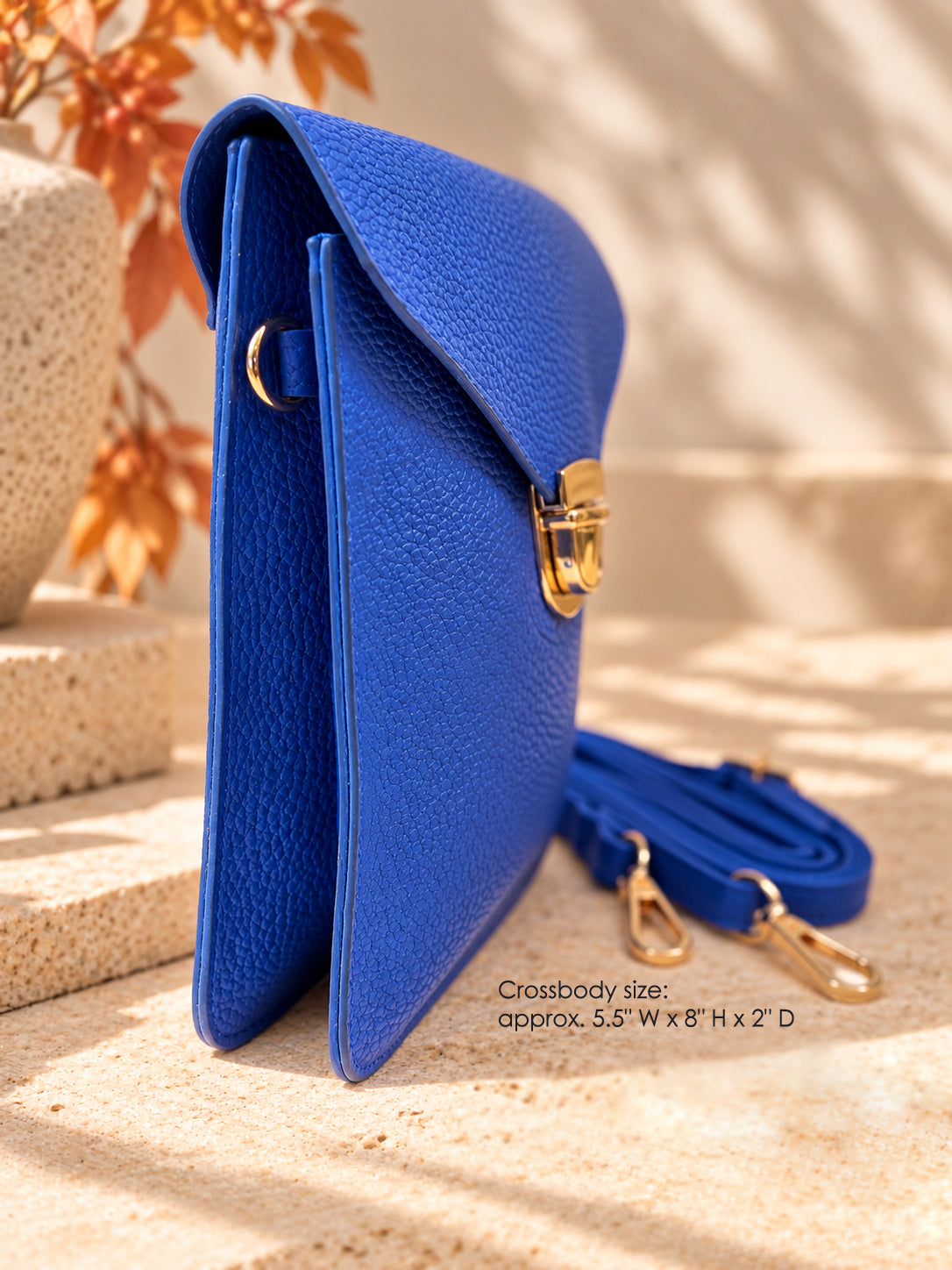 Side view of cobalt blue vegan crossbody bag with gold hardware and removable strap