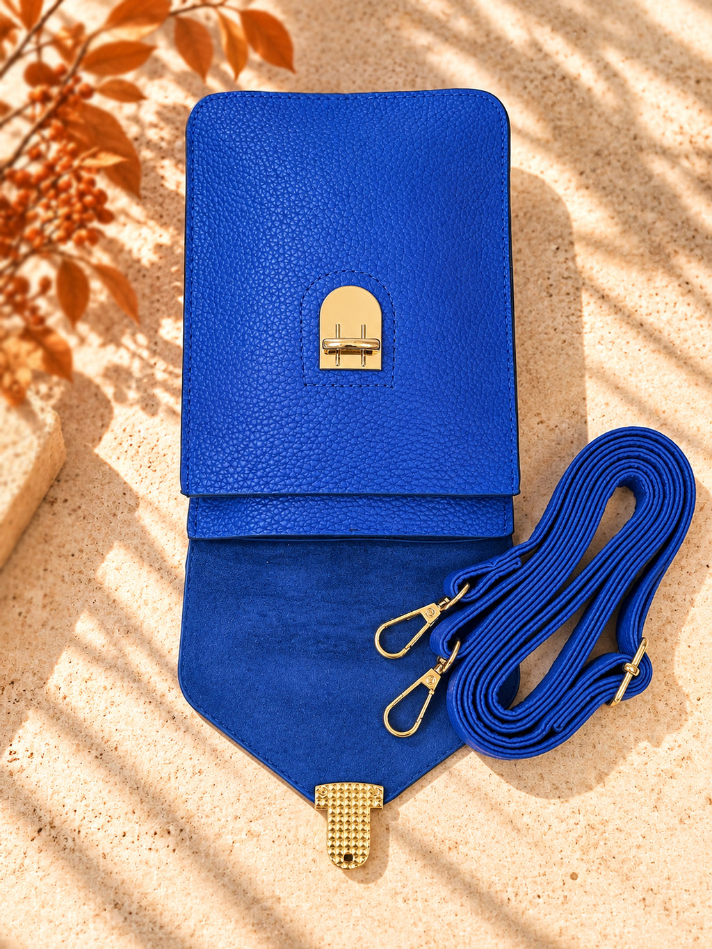 Cobalt blue crossbody bag open showing interior and adjustable strap