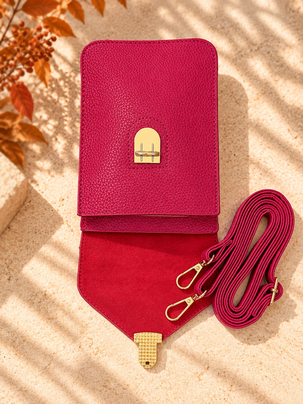 Fuchsia pink crossbody bag open showing interior and adjustable strap