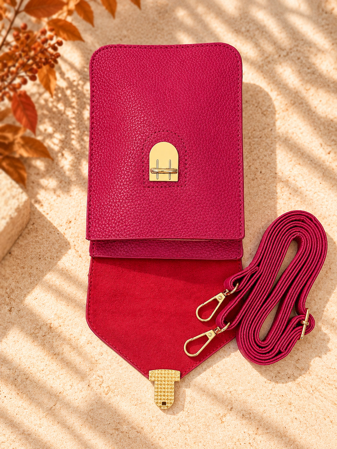 Fuchsia pink crossbody bag open showing interior and adjustable strap