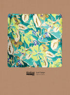 A square scarf with a vibrant floral pattern in teal, lime green, cream, and purple, displayed on a textured tan background with a 'thinking PRESENTS' brand label below.