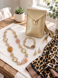 The Gold Chic Edit curated set by Thinking Presents with gold crossbody bag, natural stone necklace, bracelet, earrings and leopard-print scarf