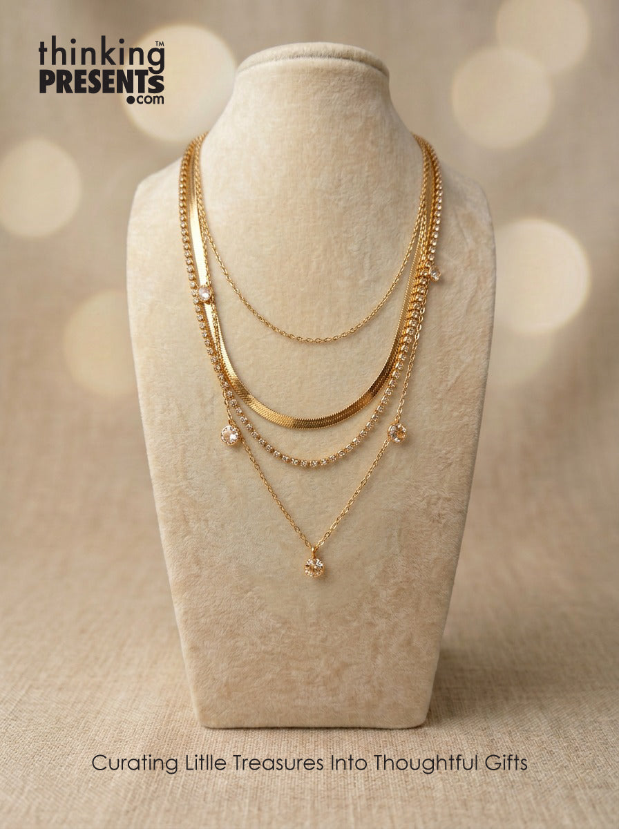Gold necklaces on a mannequin bust with 'thinking PRESENTS' branding.