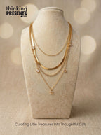 Gold necklaces on a mannequin bust with 'thinking PRESENTS' branding.