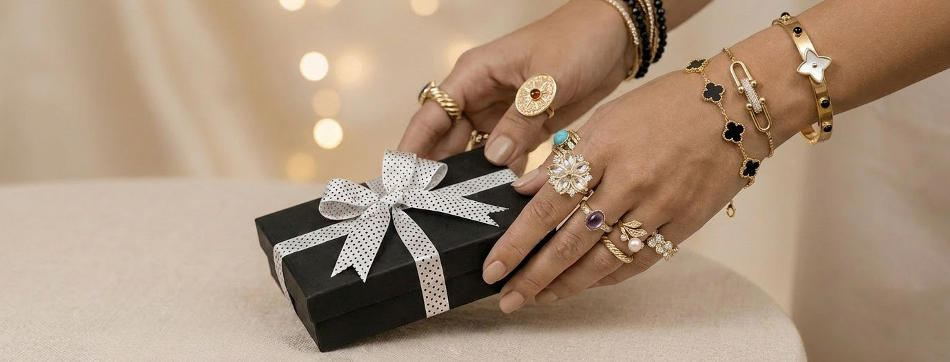 Person's hands holding a small black gift box with a white ribbon against a blurred background
