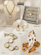 Curated gift set featuring gold-tone statement necklace with ivory pendant, twelve-piece ring set with neutral stone accents, matching drop earrings, coordinating bracelet with round ivory stones, and a silky floral scarf with velvet-touch scrunchie, styled as an elegant and refined ready-to-gift set