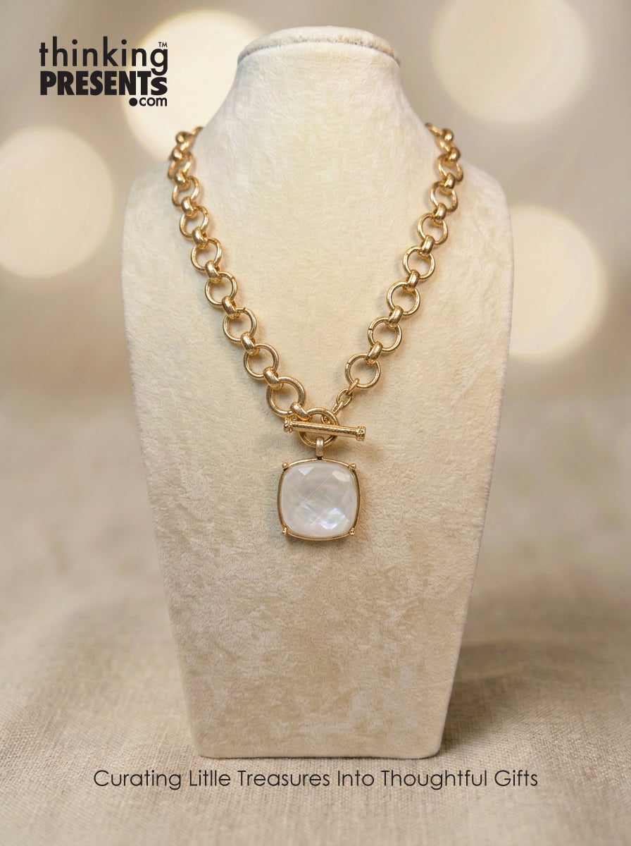 Gold-tone chain necklace with toggle clasp and square ivory pendant, styled on a neutral display, elegant and refined curated gift aesthetic
