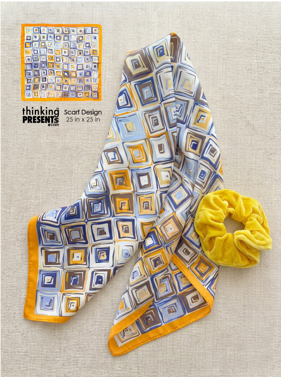 Silky geometric scarf in blue, gold and neutral tones with square mosaic pattern paired with a soft yellow velvet scrunchie