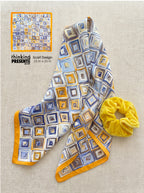 Silky geometric scarf in blue, gold and neutral tones with square mosaic pattern paired with a soft yellow velvet scrunchie