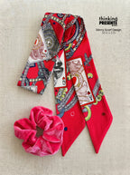 Vibrant red patterned skinny scarf with playing card and chain motifs, paired with a soft pink velvet scrunchie, styled as part of a bold and playful curated gift set by Thinking Presents™