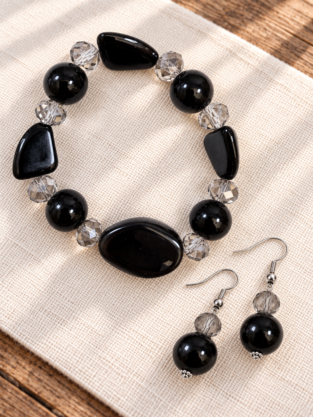 Black stone stretch bracelet and drop earrings with faceted smoky glass accents by Thinking Presents