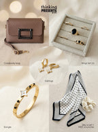 Curated gift set featuring gold-tone star charm earrings, five-piece ring set with black stone accents, structured brown crossbody bag with embellished buckle, gold bangle with star detail, and a polka dot silky scarf with velvet-touch scrunchie, styled as a chic and modern ready-to-gift set