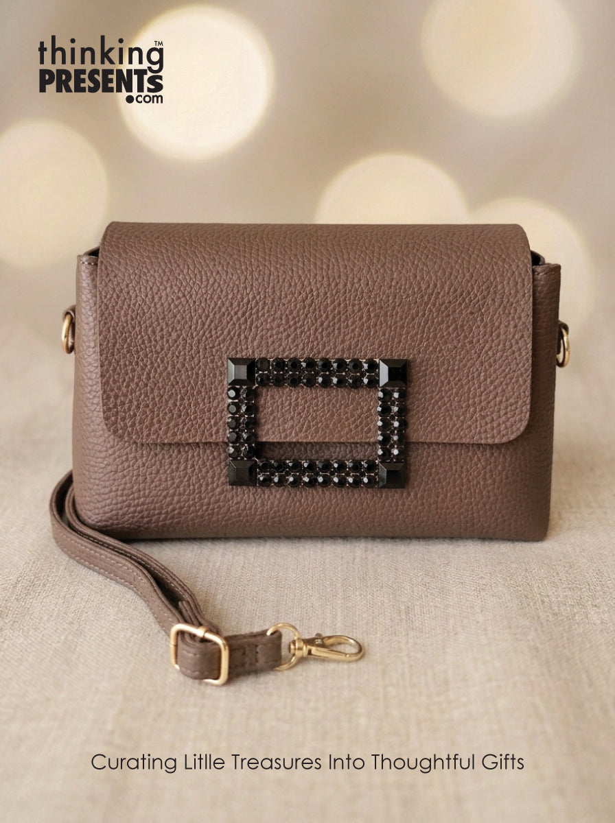 Brown handbag with decorative clasp on a beige background, featuring 'thinking presents' branding.