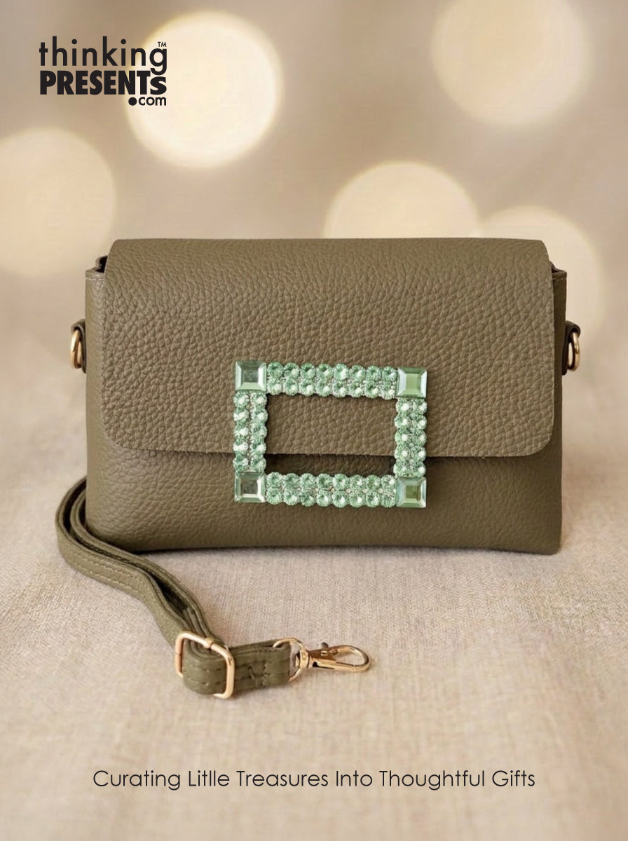 Green handbag with decorative clasp on a beige background, featuring 'thinking Presents' branding.
