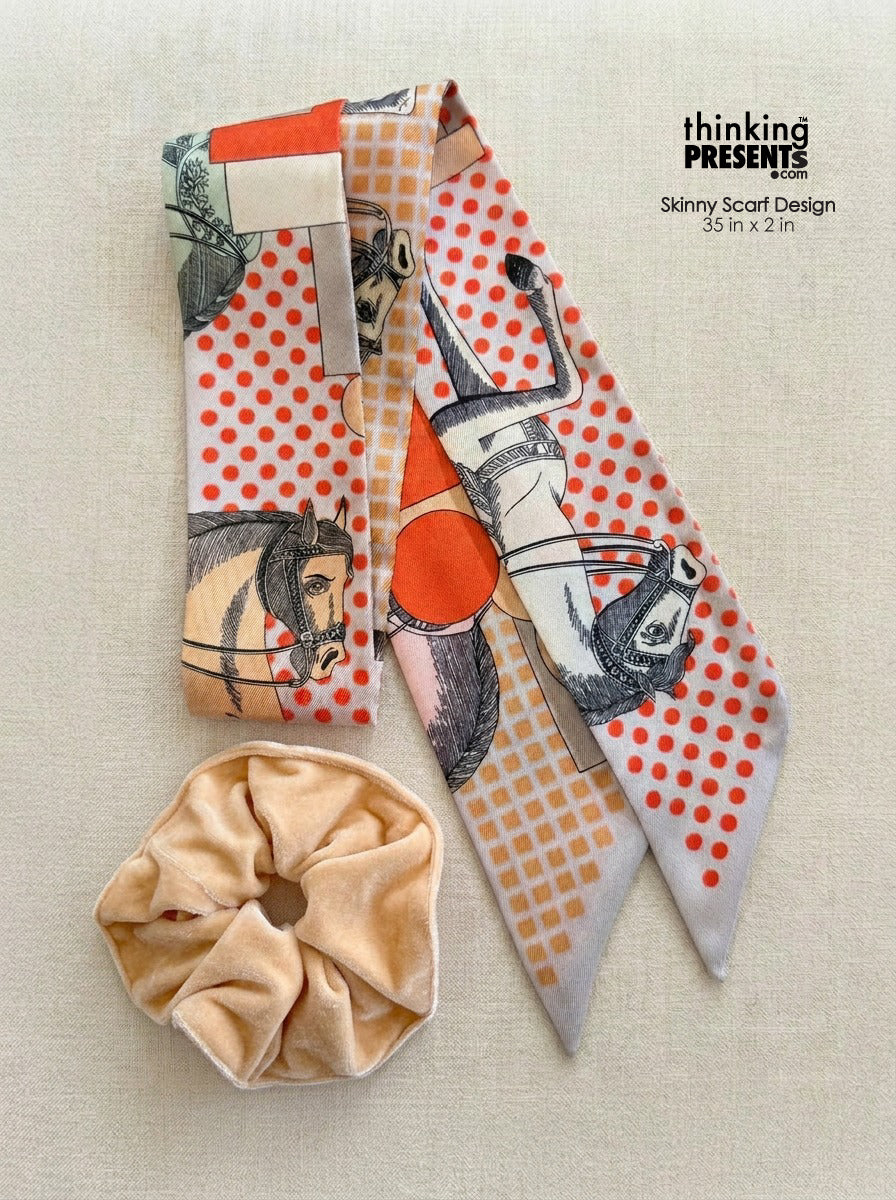Patterned skinny scarf with horse and geometric print in orange and neutral tones, paired with a soft beige scrunchie, styled as part of a chic curated gift set by Thinking Presents™