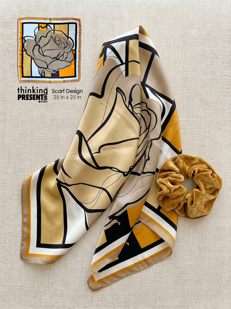 Scarf with abstract design and scrunchie on a textured surface, featuring 'thinking presents' branding.