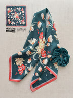 Floral patterned scarf with a matching scrunchie on a textured surface, with 'thinking presents' branding.