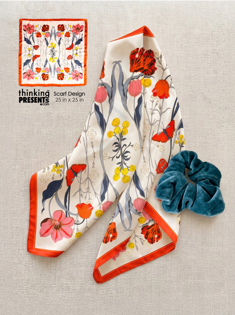 Floral scarf and blue scrunchie on a textured surface with 'thinking presents' branding.