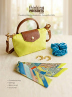 A curated gift set featuring a lime green and brown crossbody bag, a blue velvet scrunchie, gold crescent earrings, and a multicolor patterned skinny scarf, arranged on a light beige fabric surface with the 'thinking PRESENTS .com' logo at the top.