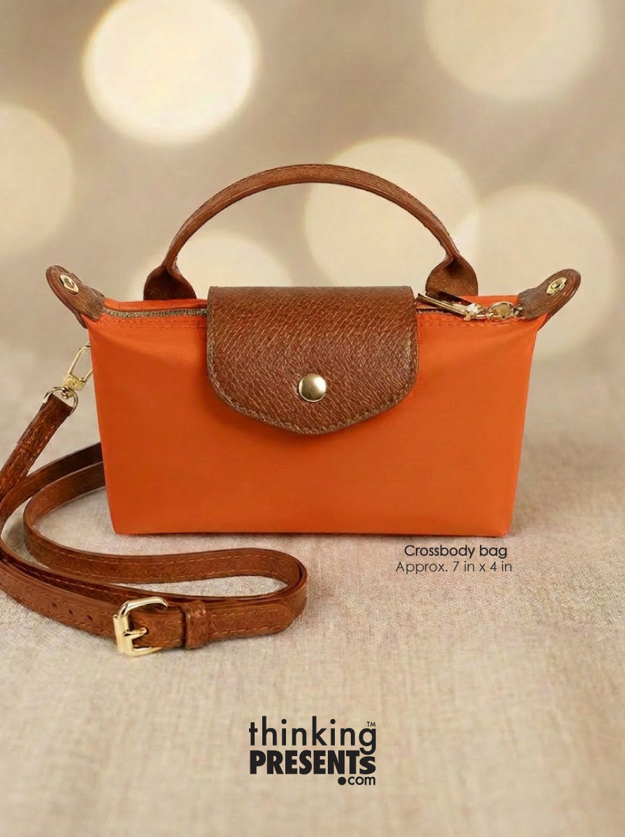 Orange crossbody bag with brown handle and strap on a beige background