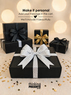 Black gift boxes with decorative bows on a light background, featuring the brand 'thinking PRESENTS'.