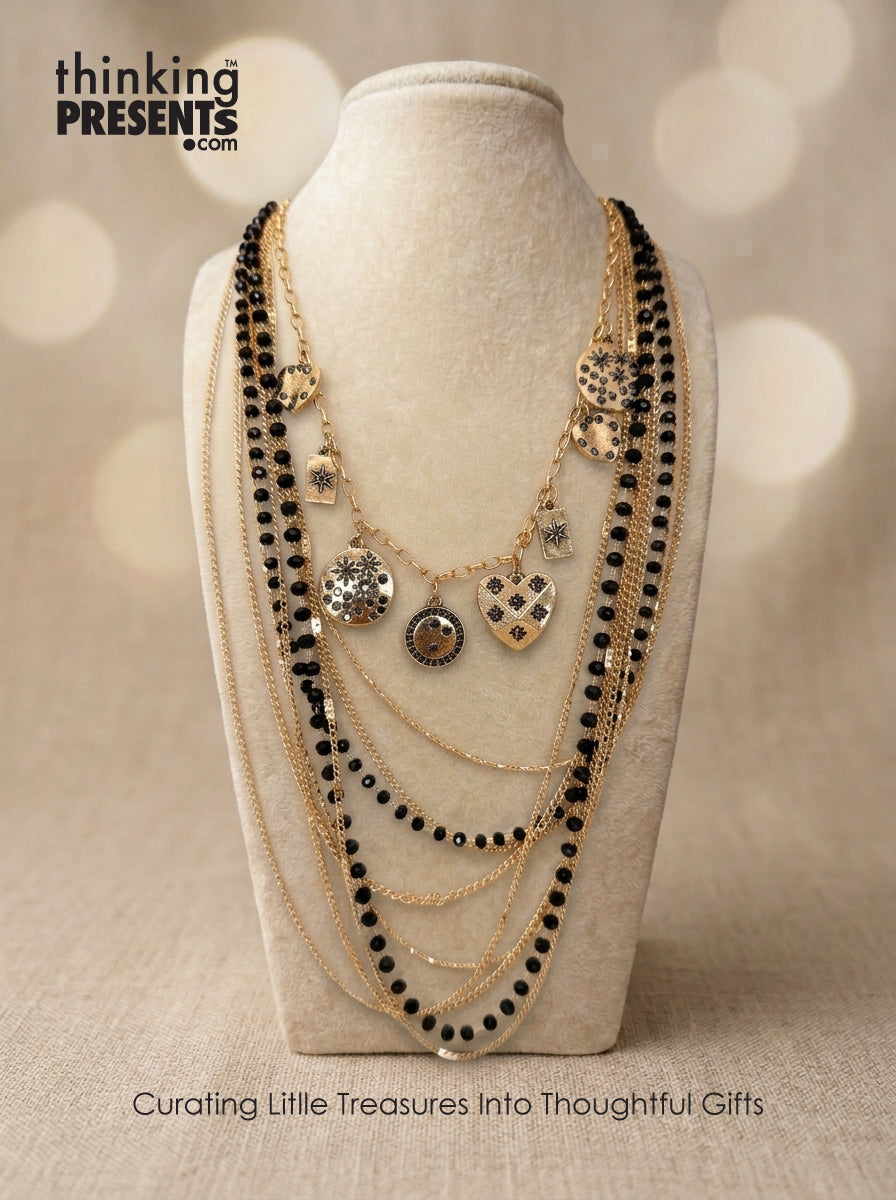Multi-layered gold-tone necklace with black bead strands and charm accents displayed on a neutral jewelry bust, part of the Urban Safari Gift Set by Thinking Presents™