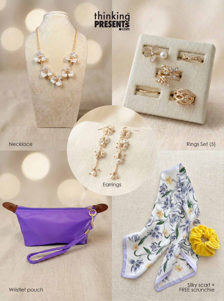 Curated gift set featuring gold-tone floral necklace, matching drop earrings, five-piece ring set, purple wristlet pouch, silky floral scarf, and yellow scrunchie, styled in a feminine, ready-to-gift presentation