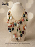Statement necklace with cascading multicolor stones and gold-tone chains, featuring layered earthy gemstone accents in a bold, boho-inspired design by Thinking Presents™